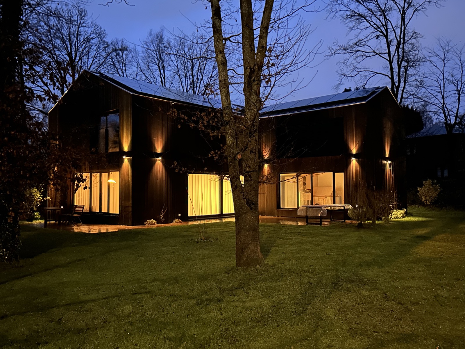 Maison passive en bois à la tombée de la nuit